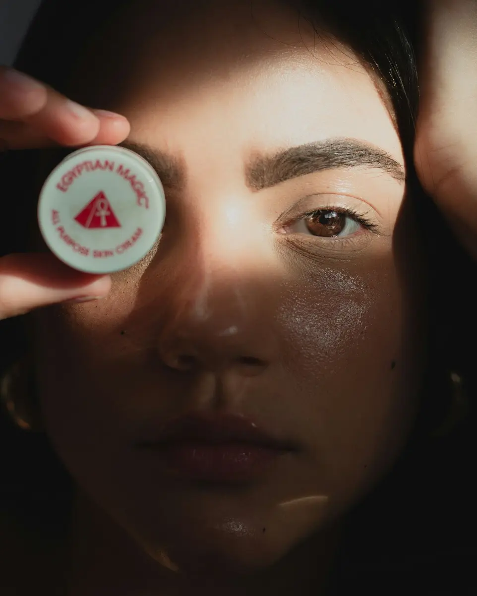 a woman holding a button up to her face